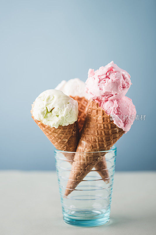 蓝色背景上的草莓和梨冰淇淋蛋卷