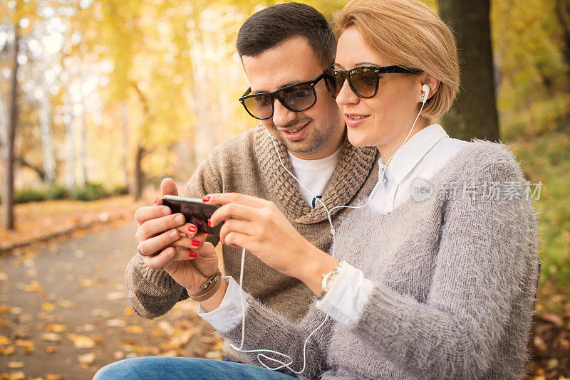 快乐的年轻夫妇看智能手机