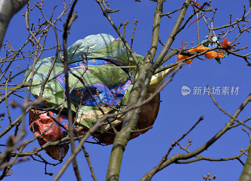 漂亮的气球把难看的垃圾扔在树上