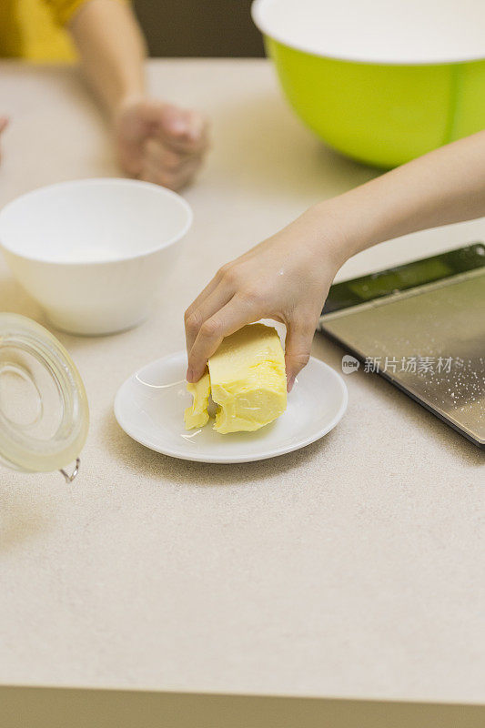 男孩伸手去拿黄油，做饼干