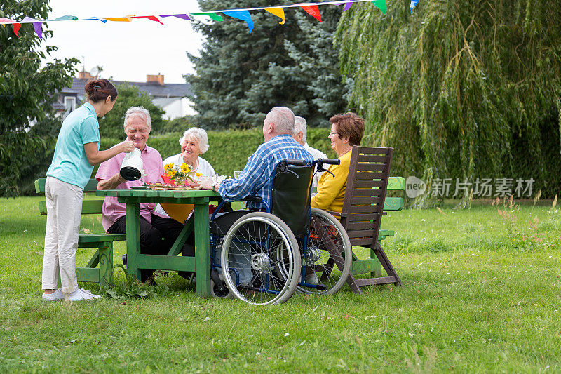 一群老人围坐在花坛桌前庆祝