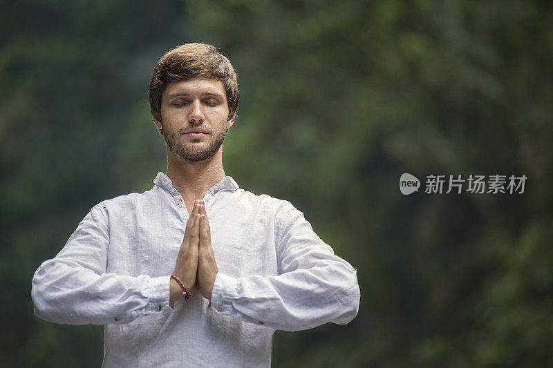 一个留着胡子的年轻人在雨林中冥想