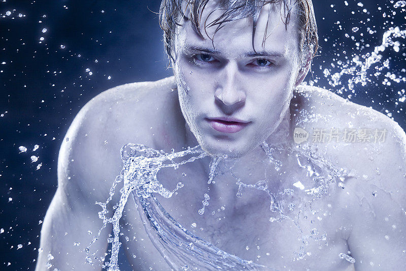 美丽强壮的男人在水滴里。