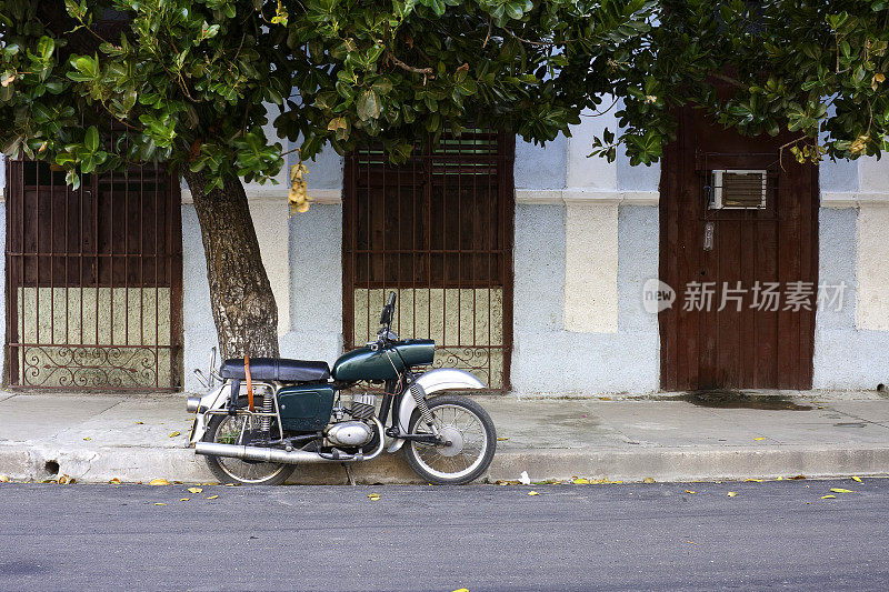 古巴西恩富戈斯，一辆停在树下的摩托车
