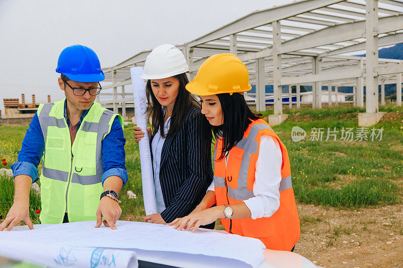 建筑工人和建筑师在建筑工地看设计图