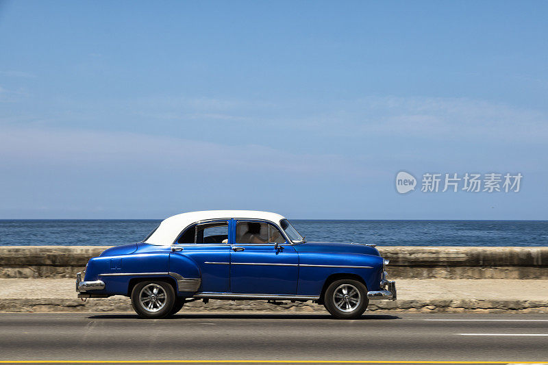古巴哈瓦那，一辆蓝色老式美国车在马勒孔高速行驶