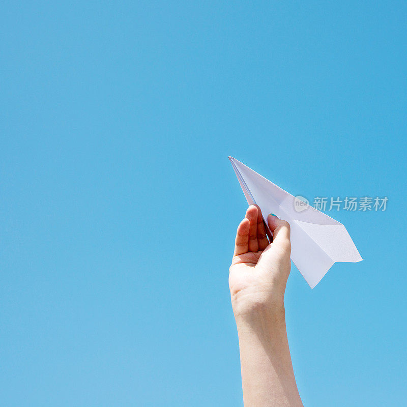 手里拿着纸飞机准备飞翔
