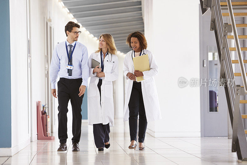 三位年轻的男医生和女医生在医院里散步