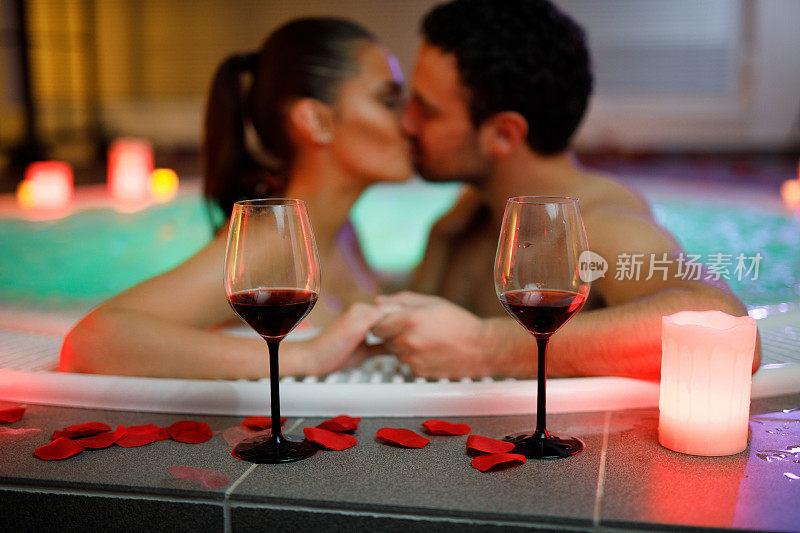 一对美丽的情侣在健康水疗中心的热水浴缸里接吻