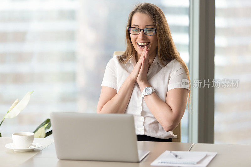 快乐的女商人开心地笑着，高兴地看着笔记本电脑的屏幕