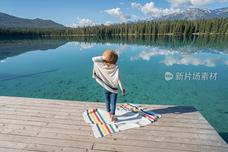 年轻女子在湖边码头欣赏山景