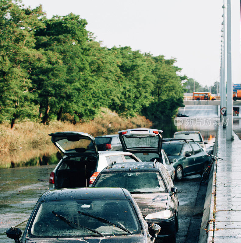 在自然灾害和暴雨后被毁的汽车淹没了道路