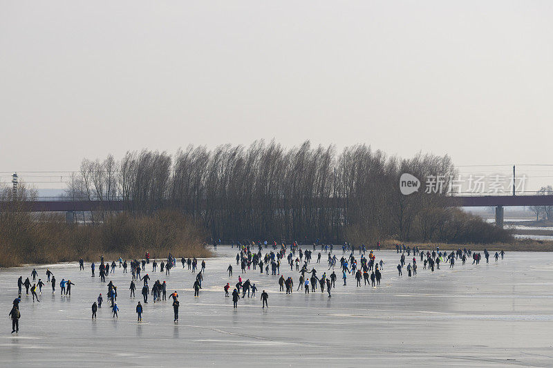 人们在兹沃勒附近的IJssel河边结冰的湖面上滑冰