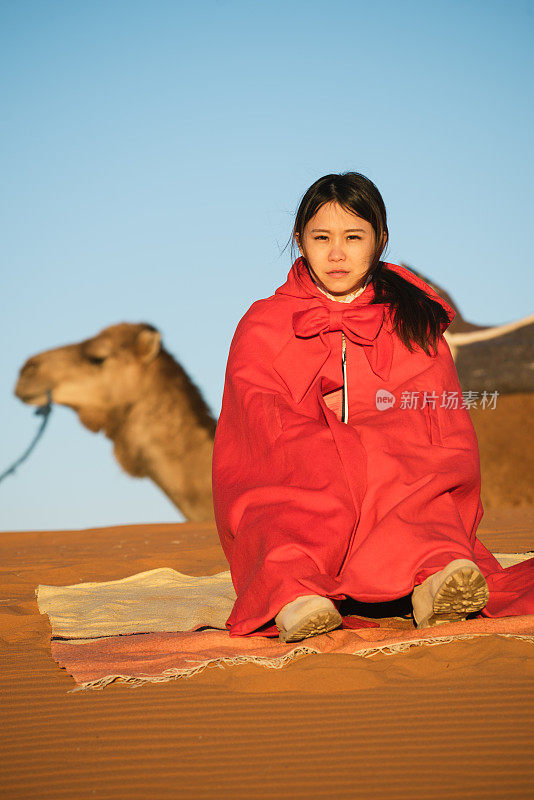 一个女人坐在非洲摩洛哥的撒哈拉沙漠上