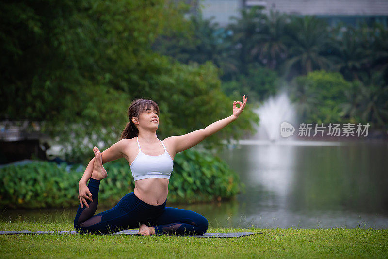 年轻的亚洲女性冥想和练习瑜伽在自然公园探索内心的平静。