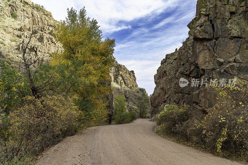 秋天在狭窄，崎岖的泥土路通过落基山峡谷