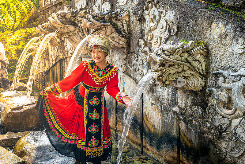 在中国云南大理蝴蝶泉公园的五龙池喷泉前，身着白族传统民族服装的妇女