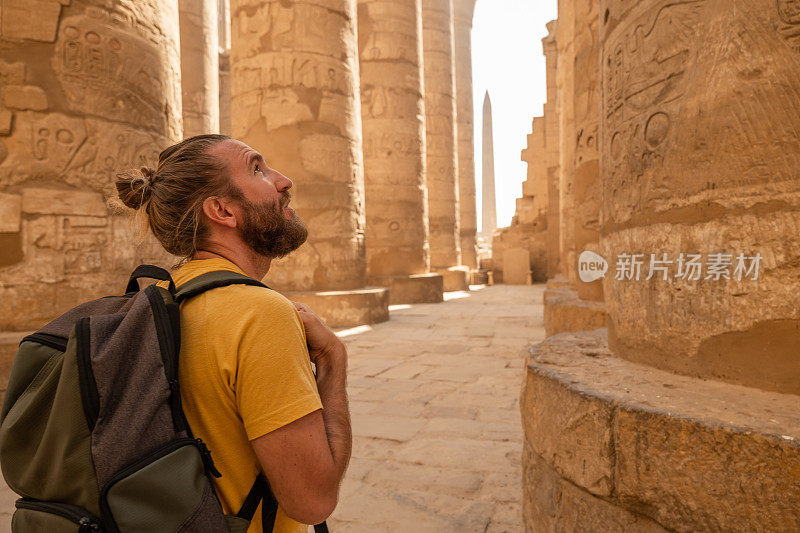 一名游客在埃及古庙的大柱子之间行走