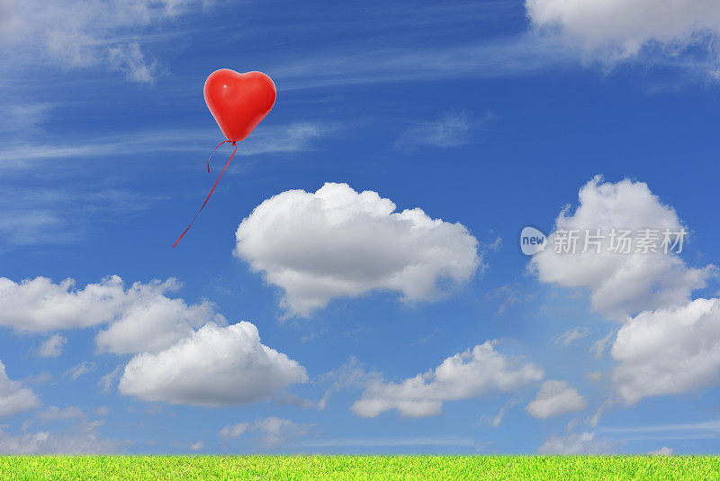 一个红色的心形气球在蓝色的天空中漂浮。