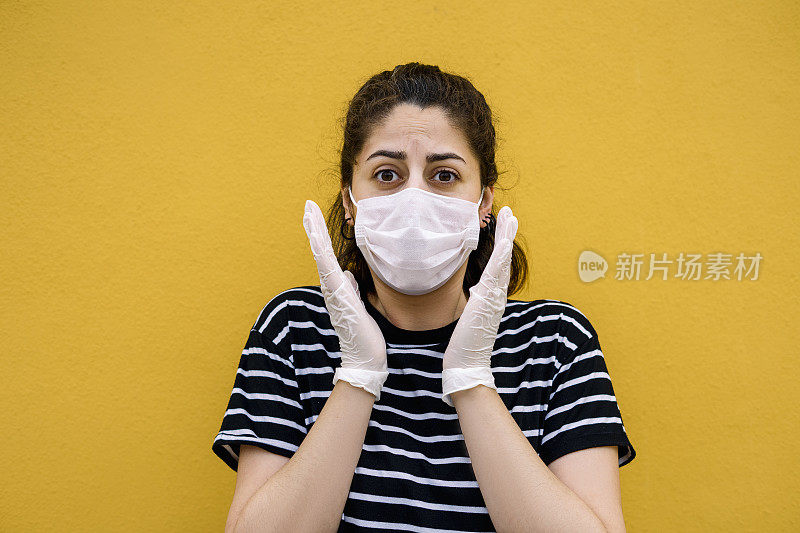 黄色背景下戴着手套和口罩的美女恐慌情绪表达