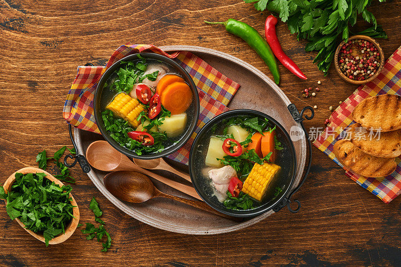 智利肉汤，小南瓜，玉米，新鲜香菜和土豆，旧木桌背景。做到。Latinamerican食物。