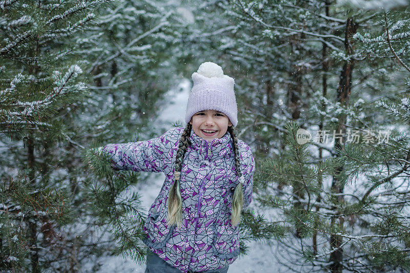 雪天，冬天的仙境，小女孩和家人在森林里散步，享受着第一场雪