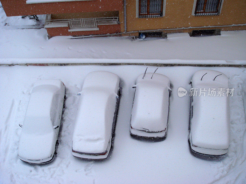 停在公寓停车场的汽车上都是雪