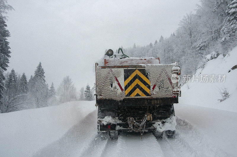 扫雪车在冬天清理森林里的道路。