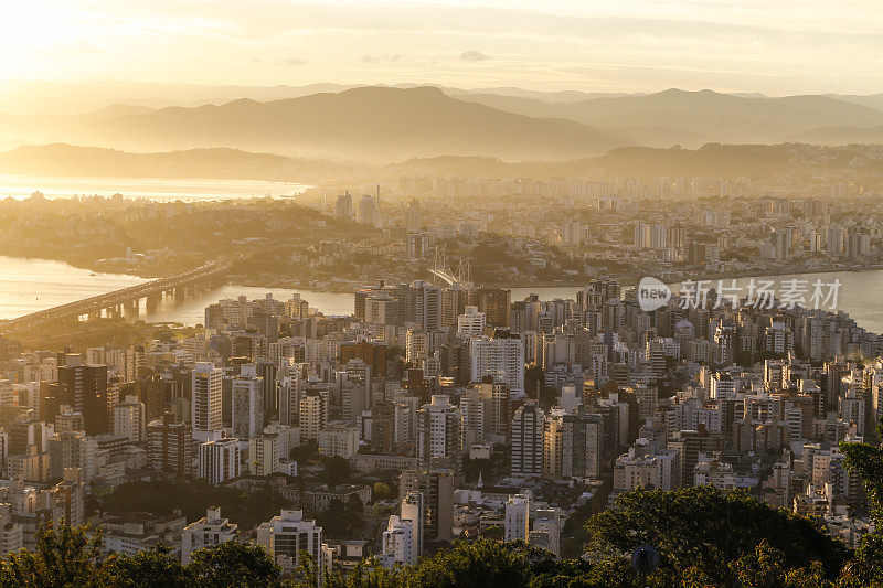 大城市傍晚的全景，海湾和大海在引人注目的天空和云彩中