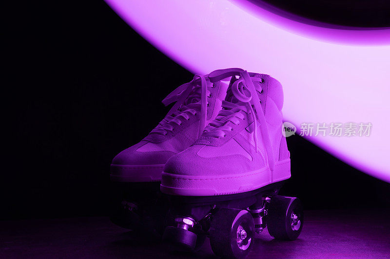 在黑色的背景下，溜冰鞋在迪斯科灯光下闪闪发光。