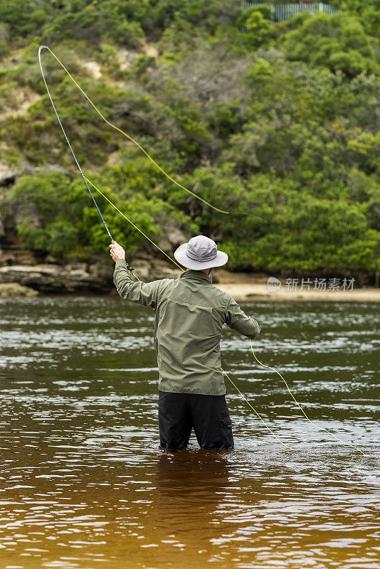 渔夫站在湖里飞钓