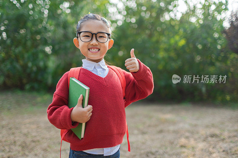 拿着书竖起大拇指的女学生