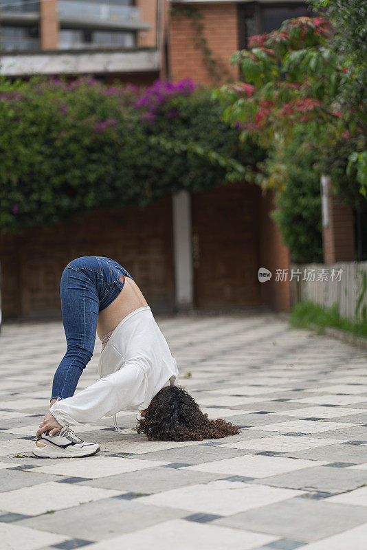 一位美丽的女子在城市的街道上进行瑜伽练习