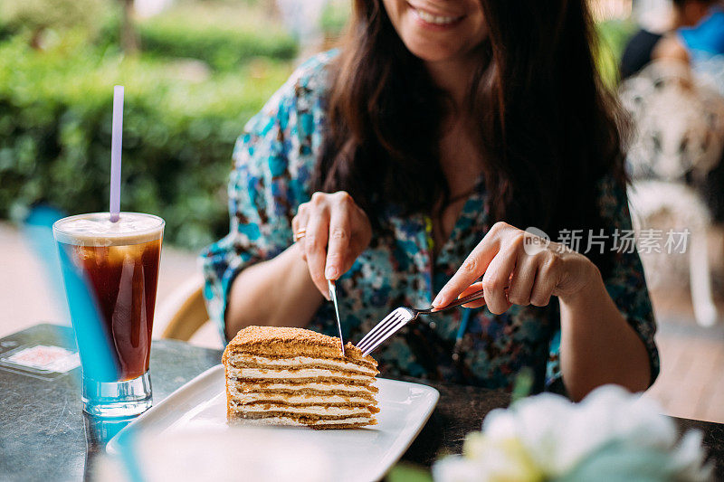 在炎热的阳光下吃着蜂蜜蛋糕和冰美式咖啡