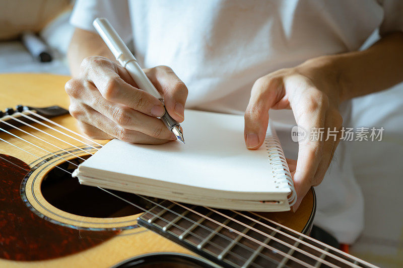 音乐家用笔和笔记本写一首歌