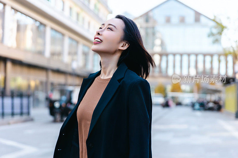 成功的女经理站在城市的大街上。