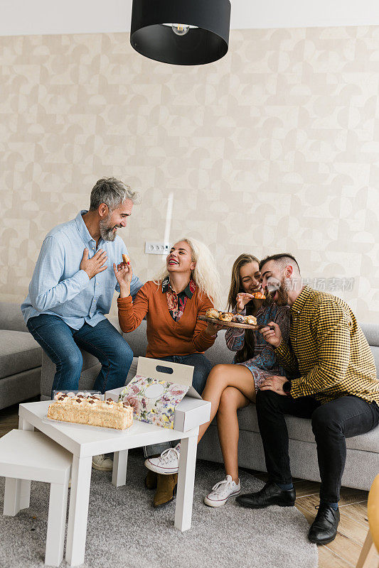 快乐的老人与他们的女儿和她的丈夫在客厅度过美好的时光。