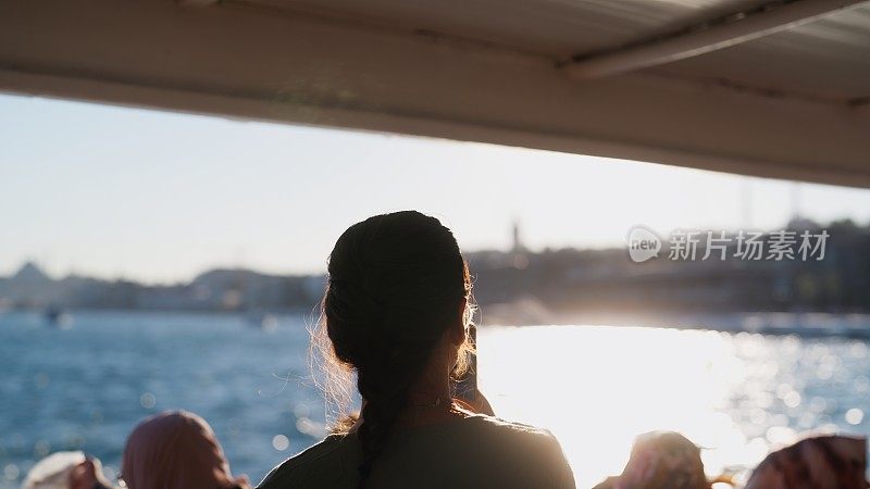 年轻女游客喜欢乘坐渡轮旅行，并在旅途中拍摄照片和视频