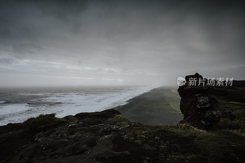 在冰岛，美丽的大海被笼罩在雾中的岩层包围
