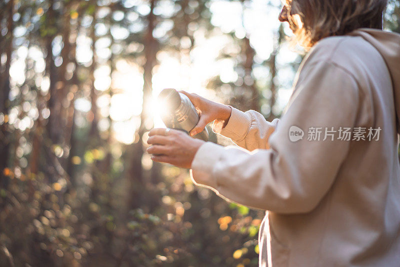 在松树林中倒茶的年轻女子