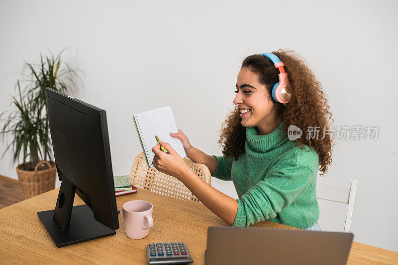 年轻女子在她的家庭办公室进行在线商务会议