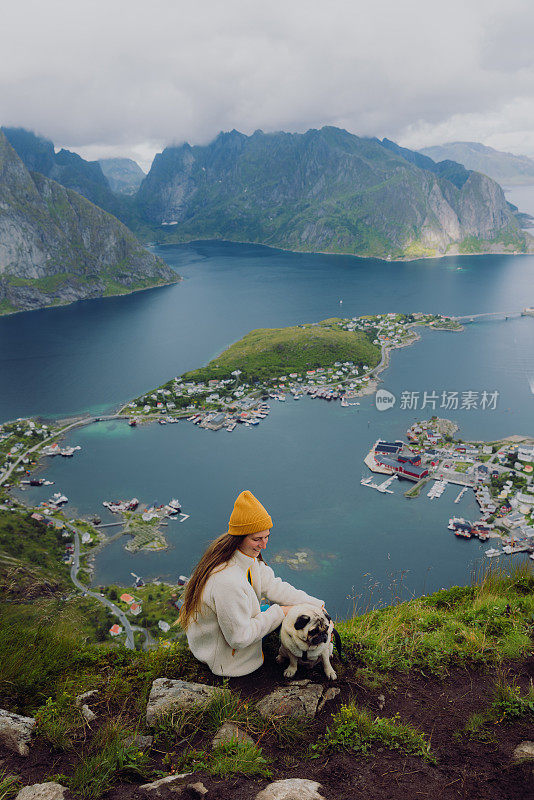 快乐的女人带着一只狗从上面俯瞰罗浮敦群岛