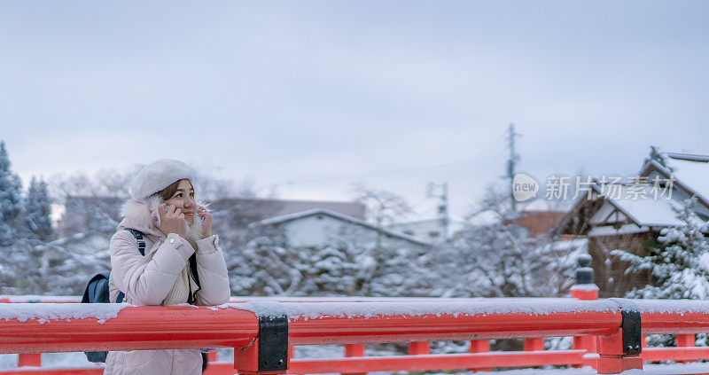 美丽的女子游客享受他们的日本之旅在雪的冬天。