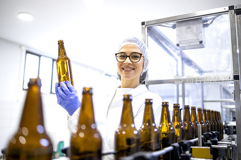 在酒精饮料装瓶厂控制啤酒生产的女工厂主管的肖像。