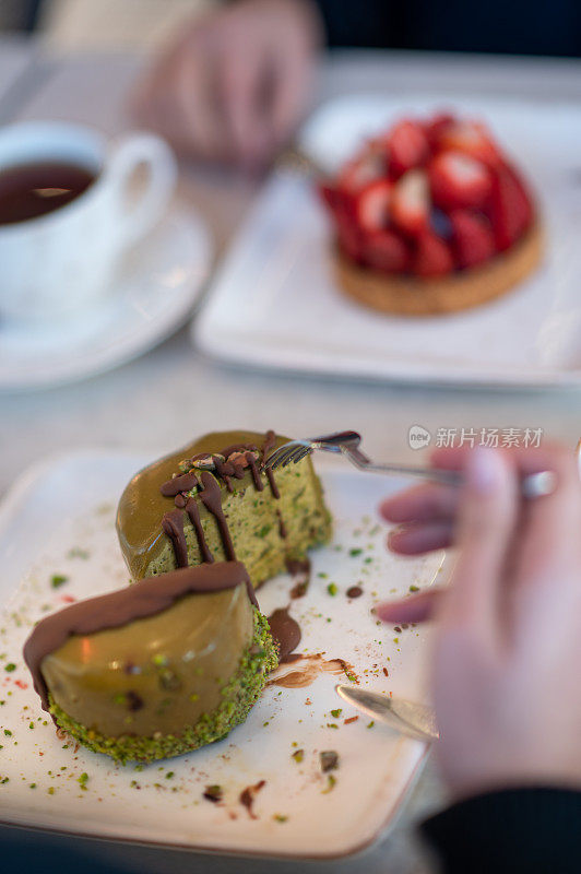 一个女人和她的朋友在café吃巧克力蛋糕的特写镜头