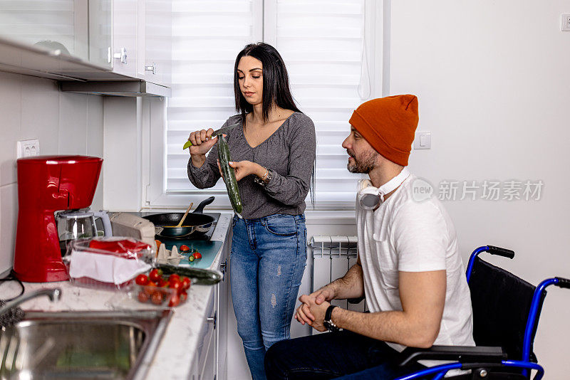 坐在轮椅上的男子在准备饭菜时得到了年轻女子的宝贵帮助