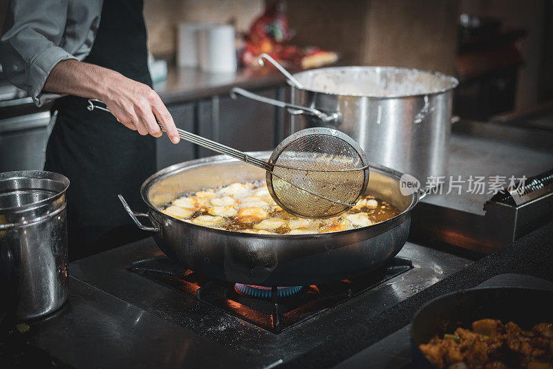 厨师在热油中准备蔬菜面团