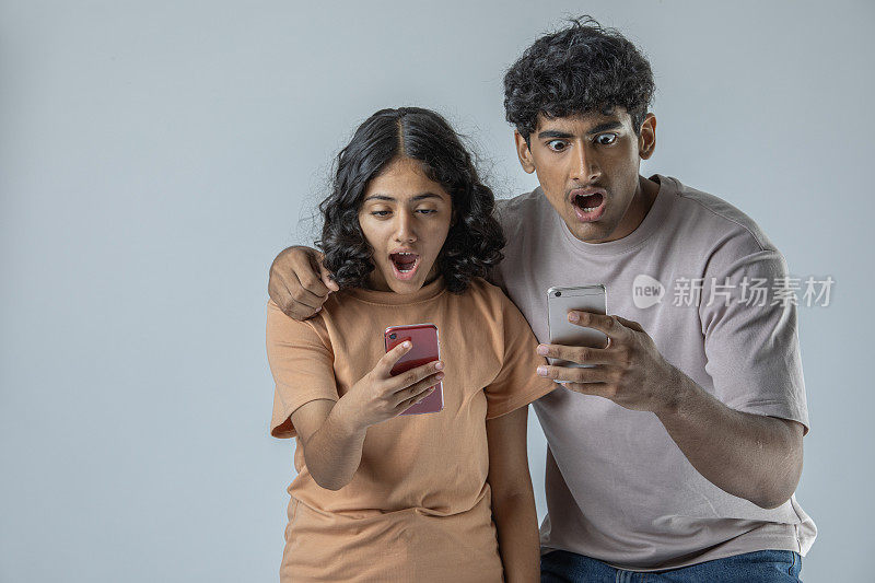 兄弟姐妹用白色背景的智能手机读坏消息