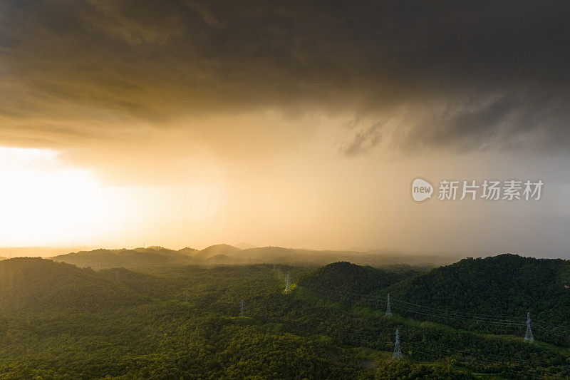 巨大的黑色雨云和暴雨落在山区的森林地区。