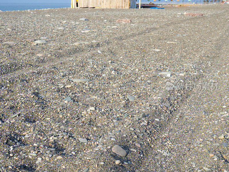 在沙地上车辙。沙滩上的车轮留下的痕迹。沙子和石头